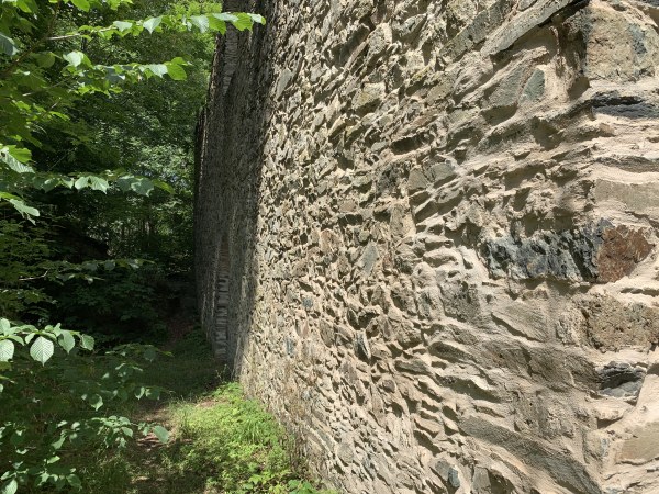 Groe Steinmauer im Wald