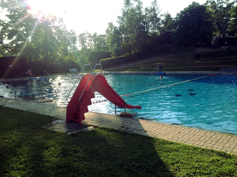 Rote Rutsche an Schwimmbecken im Grnen