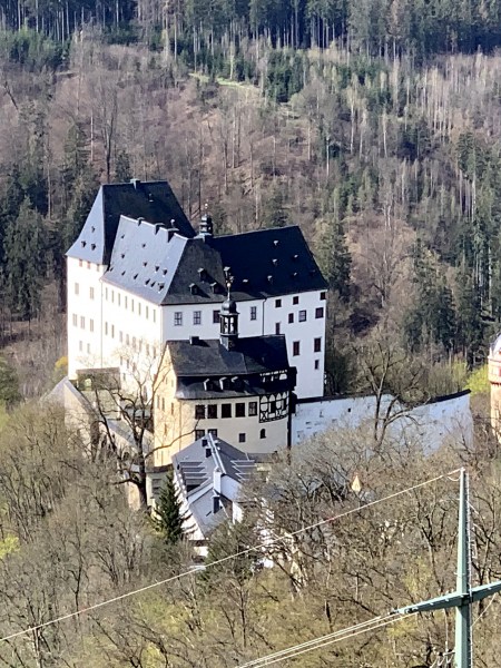 Weißes Schloss Burgk mit schwarzem Dach im Wald