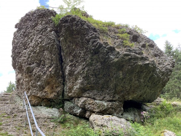 Großer Felsen. Oben leicht bewachsen. Teilweise mit Geländer.